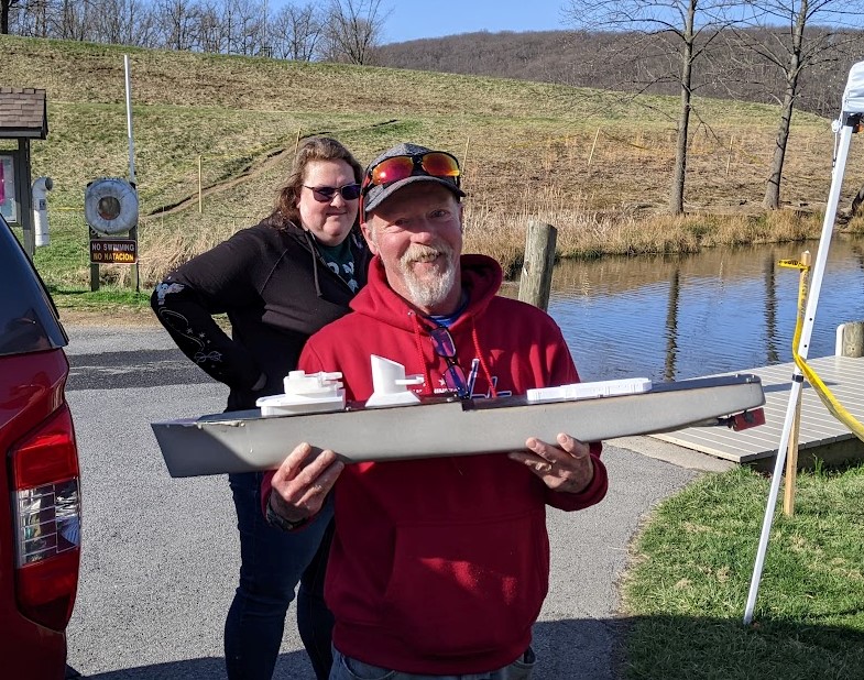 a man poses with a small model destroyer